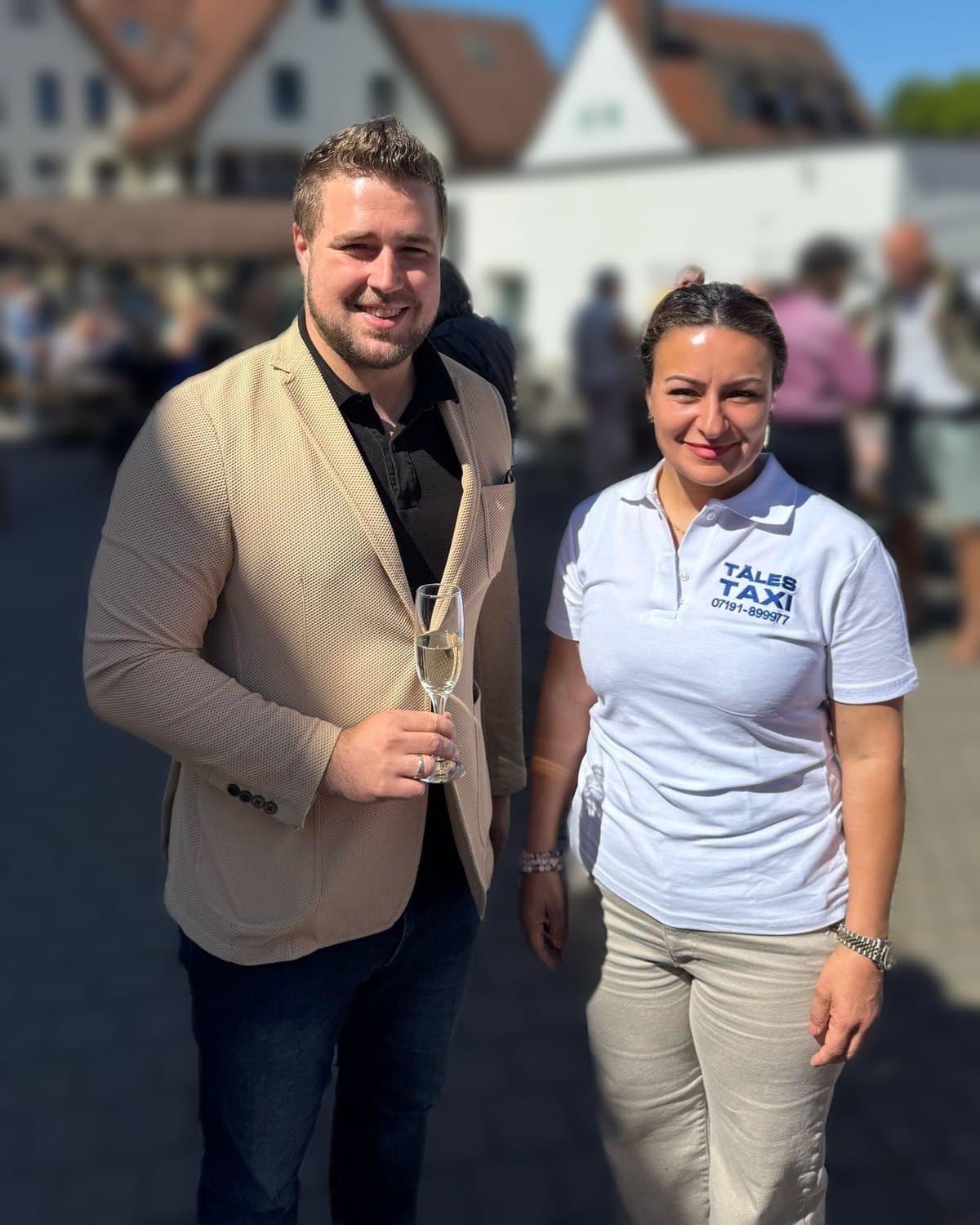 Pembe Akgün im Täles-Taxi-Poloshirt und Daniel Bogner bei einem Fest im Freien